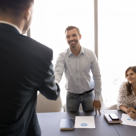 Lawyer congratulating a client with prints of IBISWorld data sheets